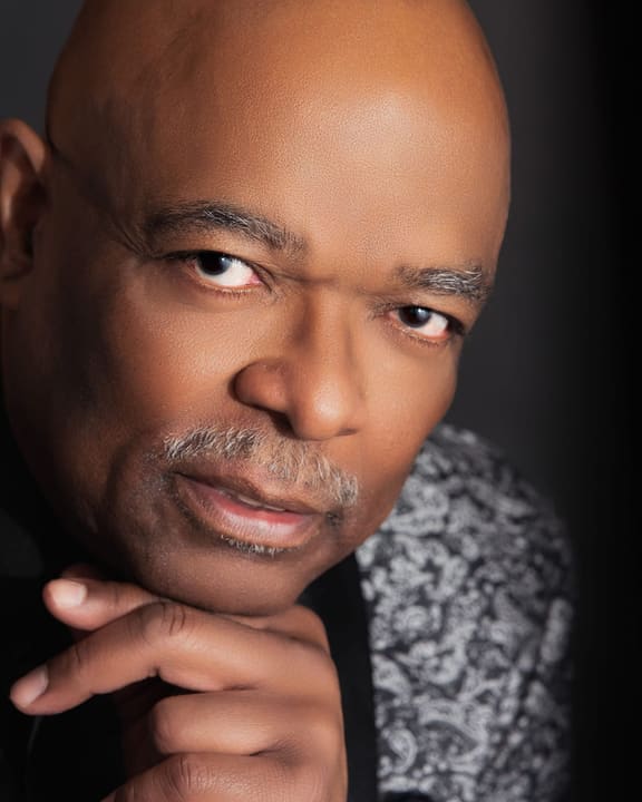 Close-up portrait of Sheldon Price, chin resting on his hand